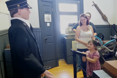 animatronic train conductor figure performing for a little girl in a train station museum
