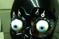 female robot face showing composite skull and blue eyes with exposed internal mechanisms and servos