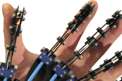 Close-up of a futuristic robotic prosthetic hand with articulated blue-and-black metal fingers, exposed linkages, screws, and hydraulic-style rods, worn directly over a real human hand for scale—showing mechanical precision and bio-integration in cybernetics