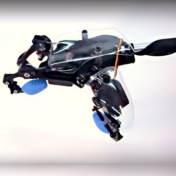 Mecha-te prototype robotic hand/arm—sleek black metal, see-through shield, articulated blue ends—hovering action shot