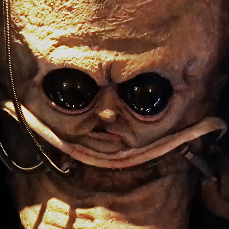 Custom Victorian-style animatronic alien in a glass display tank – detailed creepy alien head with large black eyes and mechanical details