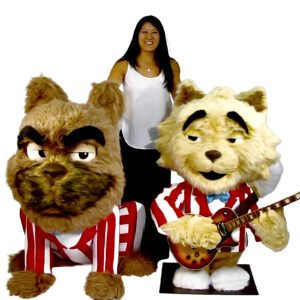 Custom animatronic bulldog mascot in business suit—furry head with grumpy expression, woman interacting at trade show booth